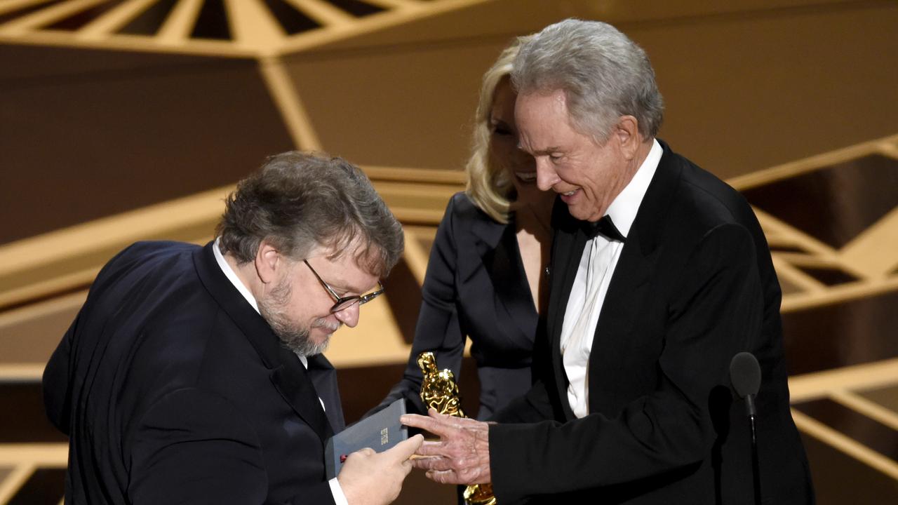 Director Guillermo del Toro inspects the envelope before accepting the best picture Oscar from Warren Beatty. Picture: AP