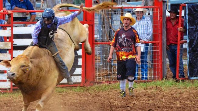 Bull rider Lane Mellers competes at Gayndah earlier this year as his uncle Brian King (right) watches on. Picture: Felicity Ripper