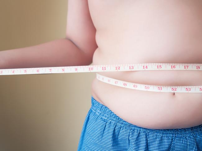 A generic stock image showing an obese or overweight child measuring his weight isolated on white background. Picture: istock