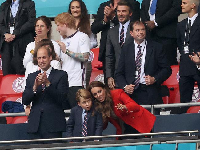 Little George looked smart in a blazer and tie as mum Kate leaned in close during the match.