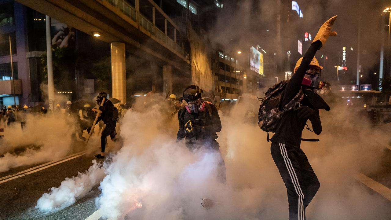 Protesters are enveloped by tear gas on an express way last night. Picture: Getty Images