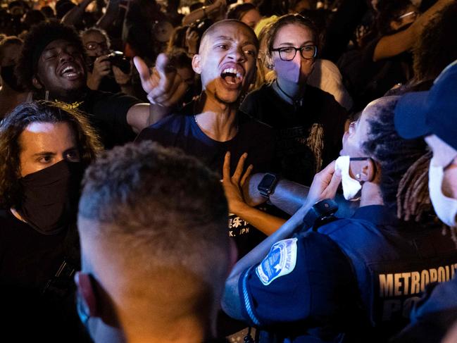 Demonstrators confront police officers during a rally to protest US President Donald Trump's acceptance of the Republican National Convention nomination at Black Lives Matter plaza across from the White House on August 27, 2020 in Washington, DC. - President Donald Trump accepts the Republican Party nomination for reelection tonight, August 27 against storm clouds of racial tension, riots and the coronavirus pandemic -- while warning of "chaos" should he lose to Democrat Joe Biden. (Photo by Jose Luis Magana / AFP)