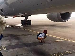 Supplied Woman blocks plane on runway. Picture: WeChat