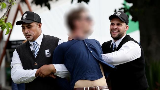 A man was escorted out by security. Picture: Jonathan Ng