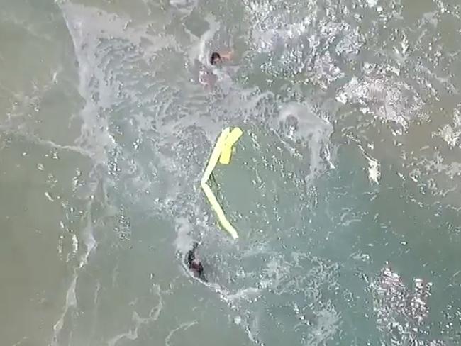 In this Thursday, Jan. 18, 2018 image made from a video provided by Westpac Little Ripper, a yellow flotation device dropped from a flying drone spread near two teenagers caught in a riptide in heavy seas off the Australian coast. A flying drone has dropped a flotation device to the pair in what officials describe as a world-first rescue. They were about a kilometer (0.6 mile) from lifeguards who were about to start training with the new drones, equipped with a camera, rescue gear and six rotors. (Westpac Little Ripper via AP)