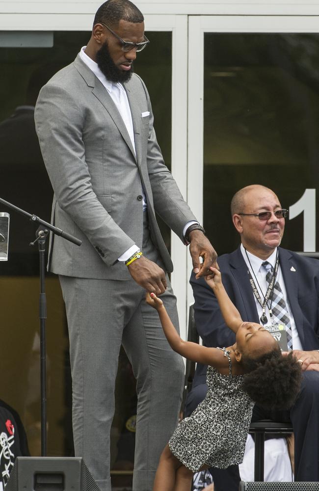 LeBron James plays with his daughter Zhuri at the opening ceremony for the I Promise School in Akron. (AP Photo/Phil Long)