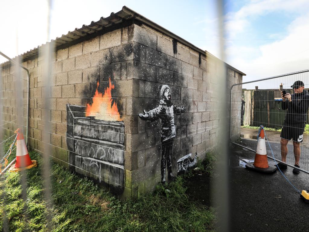 People gather around fences that have been erected to protect the latest piece of artwork by the underground guerrilla artist Banksy. Picture: Getty 