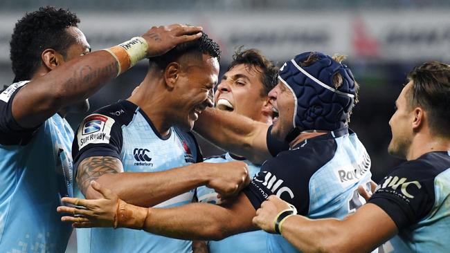 Israel Folau (second left) celebrates scoring for the Waratahs against the Rebels on Sunday.