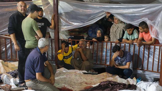 Relatives mourn over the bodies of Palestinians killed in the strike the Al-Ahli hospital in central Gaza after they were transported to Al-Shifa hopsital. Picture: AFP