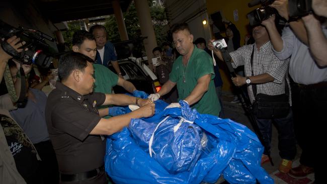 The body of David Miller, wrapped in plastic sheet, is carried at a forensic police facility in Bangkok. (AP Photo/Sakchai Lalit)