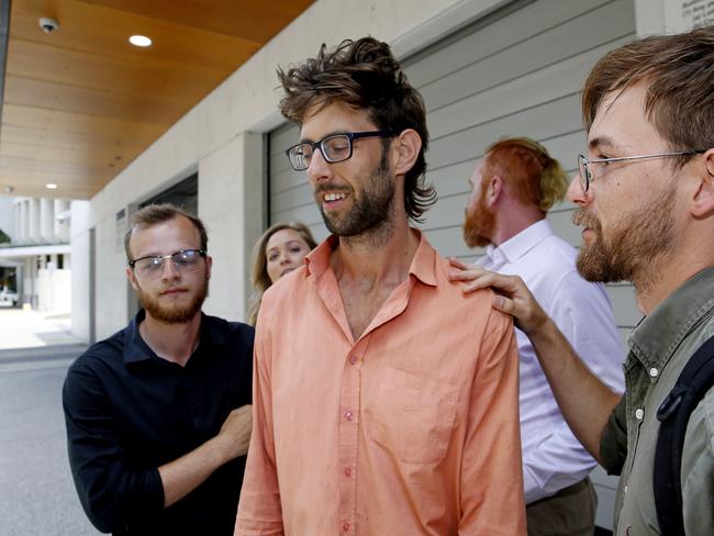 Andrew George (middle) joined by supporters as he walks free on bail from Newcastle Local Court. Picture: John Appleyard