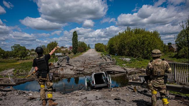 Soldiers of the Kraken Ukrainian special forces at a destroyed bridge on the road to the village of Rus'ka Lozova, near the Russian border. Picture: AFP.