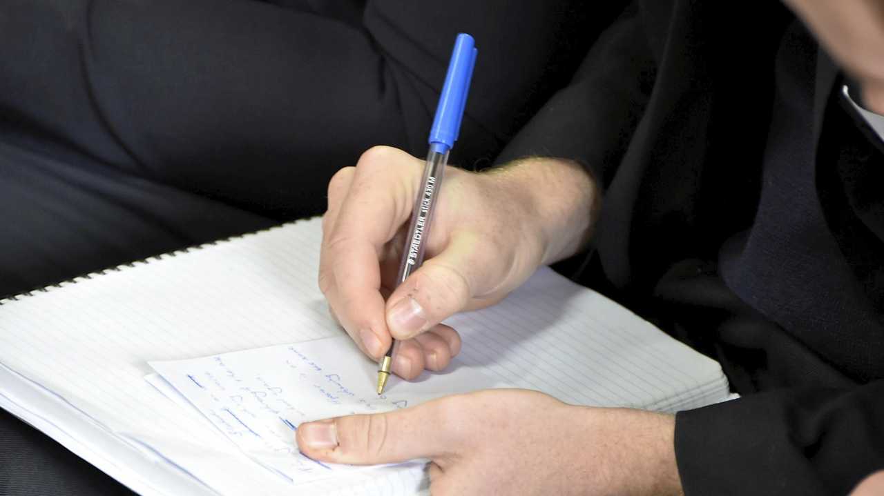 A woman writing on a note pad. Picture: Bev Lacey