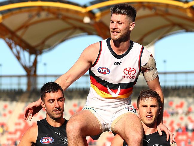 Bryce Gibbs being chaired off post-game by former teammates Kade Simpson and Marc Murphy. Picture: Chris Hyde/Getty Images