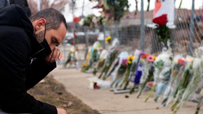 A man pays his respects to the ten victims of a mass shooting at a King Soopers grocery store in Boulder, Colorado. A 21-year-old man — Ahmad Alissa — was charged with 10 counts of murder, a day the massacre. Picture: Jason Connolly / AFP