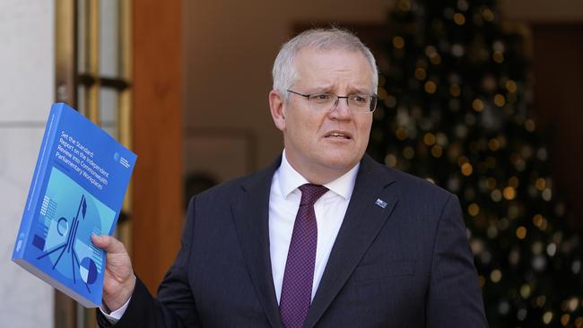 Scott Morrison holds a copy of the Jenkins review on Tuesday. Picture: Adam Taylor