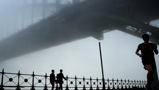 The Sydney Harbour Bridge disappears under a thick blanket of fog in Sydney, Monday.