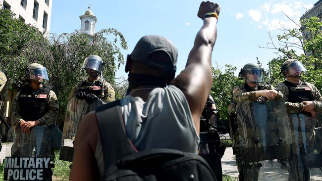 A protester kneels in front of military police near the White House. Picture: AFP