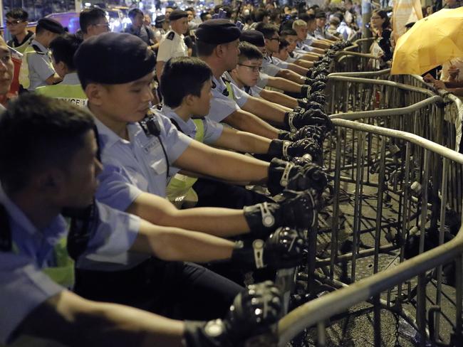 Protesters push the barriers against police outside the Chinese central government's liaison office. Picture: Vincent Yu/AP
