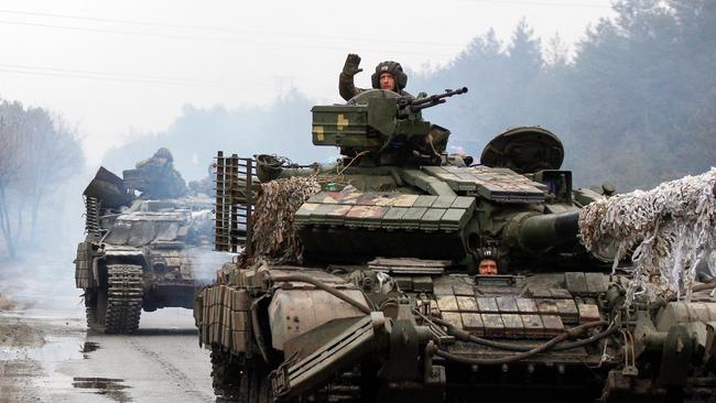 Ukrainian servicemen ride on tanks towards the front line with Russian forces in the Lugansk region of Ukraine. Picture: AFP