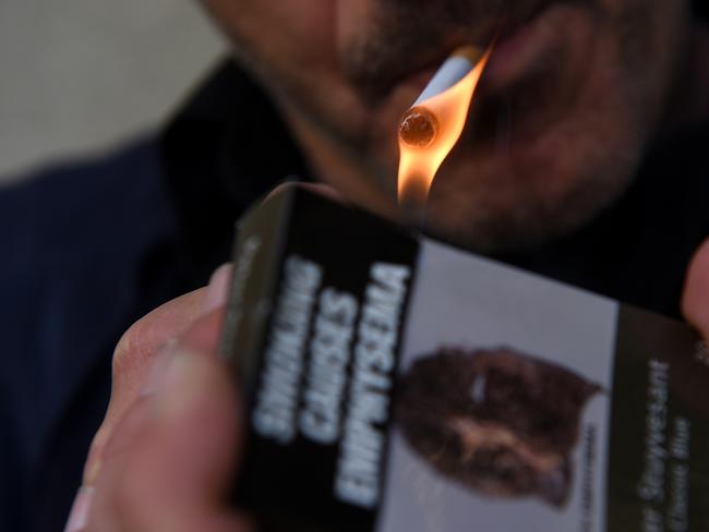 A generic image of a man pictured lighting a cigarette in Canberra, Tuesday, May 3, 2016. The Australian Labor Party has outlined a plan to increase the tobacco excise by 12.5 per cent a year, each year, from September 1, 2017 until September 1, 2020, whereby consumers would see a packet of 25 cigarettes cost more than $40 by 2020. (AAP Image/Sam Mooy) NO ARCHIVING