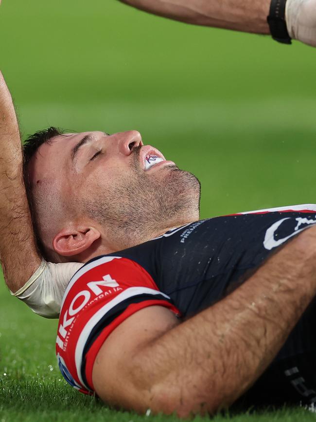 James Tedesco of the Roosters is attended to by a trainer after an attempted tackle on Viliame Kikau. Photo by Cameron Spencer/Getty Images.