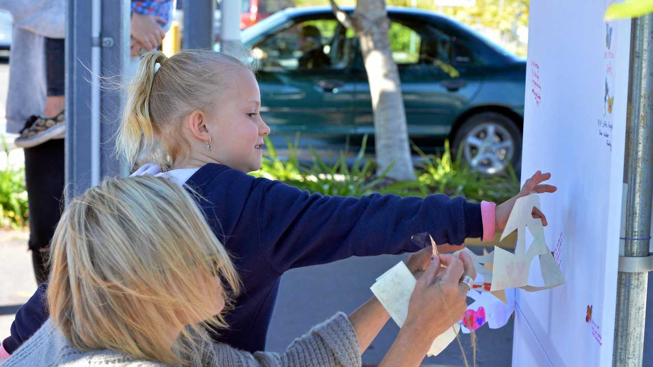 Flowers and messages have been left by Leonie Gilbertson and her daughter Aylah, 6, to pay their respects to the family of the little girl who died in Nambour afterbeing struck by a car on a pedestrian crossing. Picture: Patrick Woods