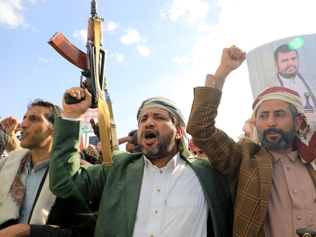 Yemeni men brandish their weapons and hold up portraits of Houthi leader Abdul Malik al-Houthi during a protest in solidarity with the Palestinian people in the Houthi-controlled Yemeni capital Sanaa. Picture: AFP