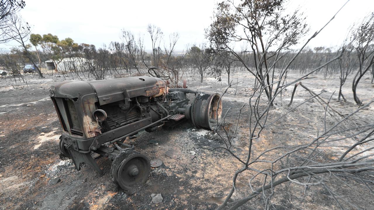 A burnt-out tractor sits amid a wasteland of ash. Picture: Tait Schmaal