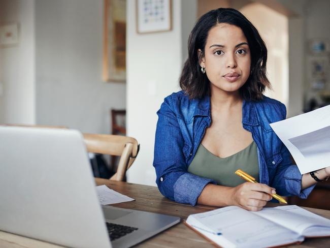 CAREERS FOR JAN 19: Shot of a young woman using a laptop and  going through paperwork while working from home.