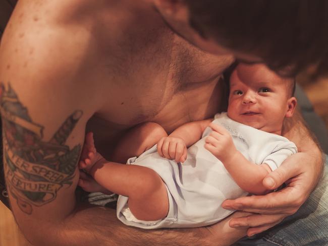 Cute newborn baby feet in father hands