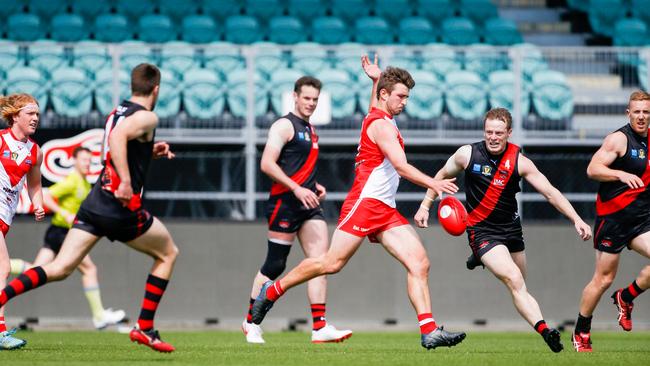 Clarence's Jarrod Harper kicks forward at North Launceston's Mark Walsh closes in. Picture: PATRICK GEE