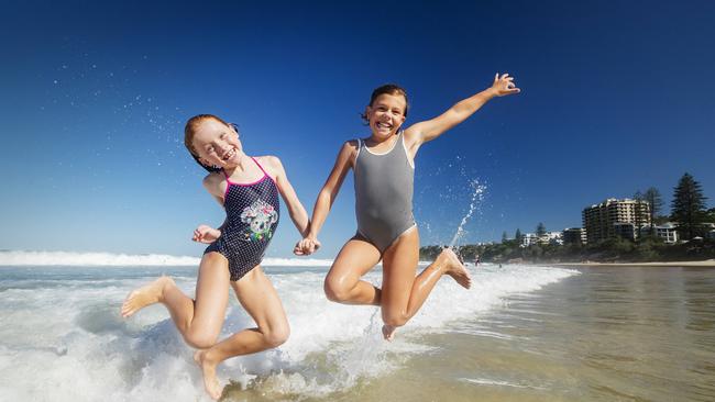 Best mates Indi Wayland, 8, and Ivy Buswell, 8, cool off at Coolum after school on a sweltering day across Queensland today. Picture: Lachie Millard