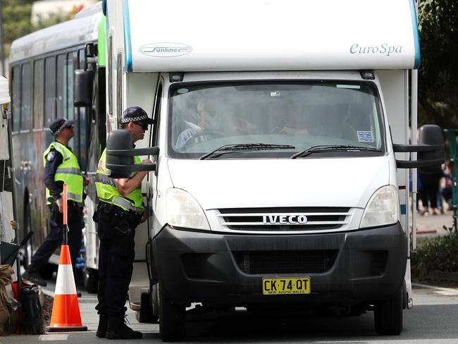 Queensland police check vehicles at the border with NSW ... travellers from Sydney will be forced to spend two weeks in mandatory quarantine at their own expense if they come to the NT from Friday. Picture: Nigel Hallett