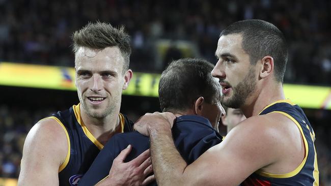 Brodie Smith — in his first AFL game since last year’s finals series — and Taylor Walker hug Don Pyke after the win. Picture: SARAH REED