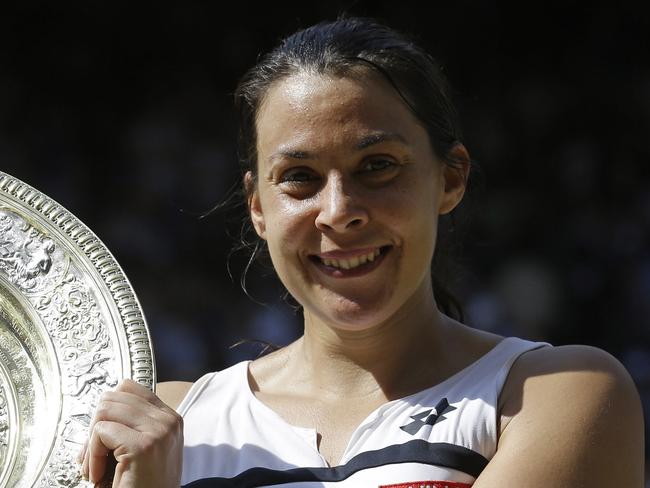 FILE - In this July 6, 2013, file photo Marion Bartoli, of France, smiles as she holds the trophy after winning the women's singles final match against Sabine Lisicki of Germany at the All England Lawn Tennis Championships in Wimbledon, London. Bartoli says she is coming out of retirement and returning to the tennis tour next season. The 33-year-old Frenchwoman made the announcement via a Twitter post on Tuesday, Dec. 19, 2017. (AP Photo/Anja Niedringhaus, File)