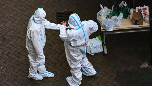 Security guards at the entrance of a compound under Covid-19 lockdown in the Jing'an district in Shanghai.