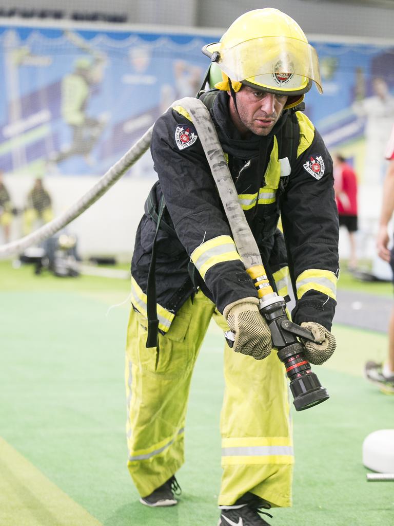 Tony Abiassaf shows his strength by carrying the fire hose. Picture: Dylan Robinson