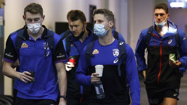 MELBOURNE, AUSTRALIA - MAY 30: Bailey Dale, Jack Macrae, Lachie Hunter and Jordon Sweet of the Bulldogs are seen at Melbourne Airport on May 30, 2021 in Melbourne, Australia. The Western Bulldogs will base themselves in Sydney for the week as Victoria remains in lockdown due to a COVID-19 cluster outbreak in Melbourne's northern suburbs. During the seven-day "circuit-breaker" lockdown residents can only leave home for five reasons: care and caregiving, exercise, work, to buy groceries, or to get vaccinated. The lockdown is effective from 11:59 pm Thursday 27 May to 11:59 pm Thursday 3 June 2021. (Photo by Daniel Pockett/Getty Images)