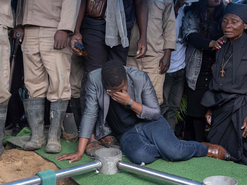 Relatives and friends mourn during the burial of the coffin at the funeral of Elvino Dias, lawyer of the presidential candidate of the opposition.