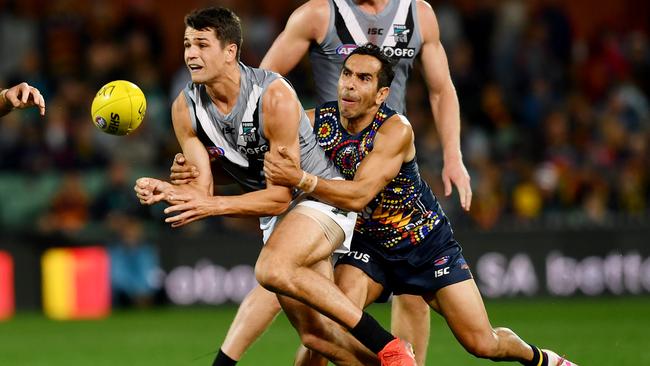 Ryan Burton of Port Adelaide handballs as he is tackled by Eddie Betts of the Crows. Picture: Mark Brake/Getty Images