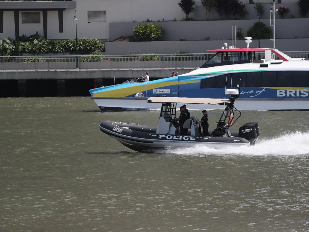 Water police are deployed as a protester hangs from the Story Bridge. Picture: Peter Wallis