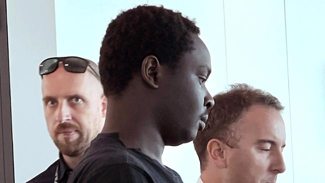MELBOURNE AUSTRALIA - Newswire Photos JANUARY 15TH 2023 : Accused murderer Koang Wuordol, arrested over the murder of Sudanese teenager Yiel Gatluak, boards a Qantas flight at Melbourne Airport, and is extradited to Alice Springs. PICTURE : NCA Newswire / Nicki Connolly