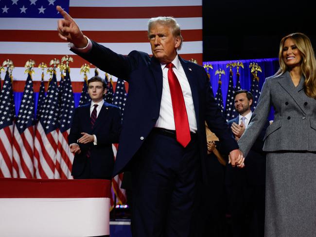 WEST PALM BEACH, FLORIDA - NOVEMBER 06: Republican presidential nominee, former U.S. President Donald Trump points to supporters with former first lady Melania Trump during an election night event at the Palm Beach Convention Center on November 06, 2024 in West Palm Beach, Florida. Americans cast their ballots today in the presidential race between Republican nominee former President Donald Trump and Vice President Kamala Harris, as well as multiple state elections that will determine the balance of power in Congress.   Chip Somodevilla/Getty Images/AFP (Photo by CHIP SOMODEVILLA / GETTY IMAGES NORTH AMERICA / Getty Images via AFP)