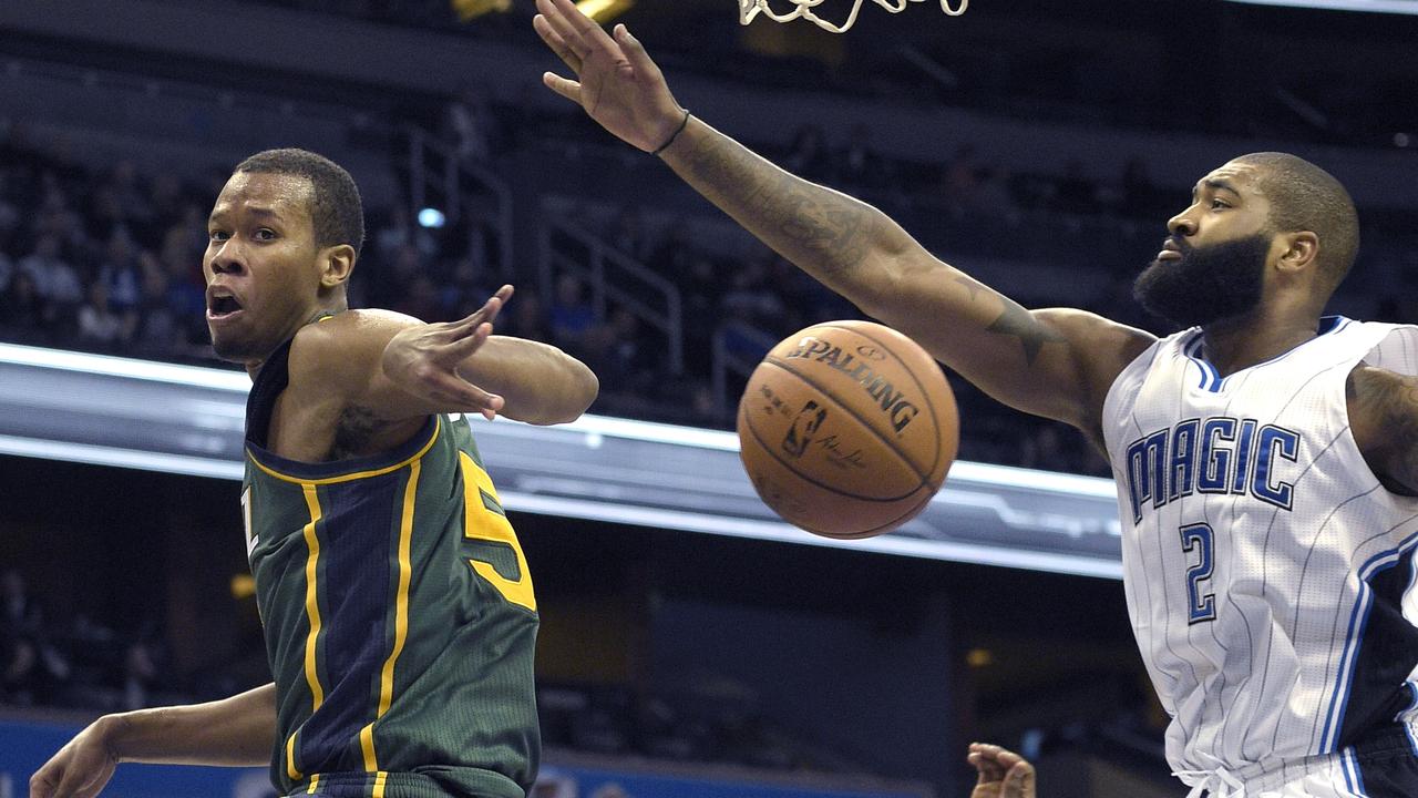 Utah Jazz guard Rodney Hood (5) passes the ball behind his back past Orlando Magic forward Kyle O'Quinn (2) during the second half of an NBA basketball game in Orlando, Fla., Friday, Dec. 19, 2014. The Jazz won 101-94.(AP Photo/Phelan M. Ebenhack)