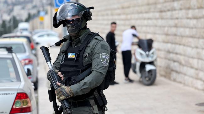 An Israeli security officer watches Muslim Palestinians as they take part in Friday Noon prayers in East Jerusalem neighbourhood of Ras al-Amud. Picture: AFP