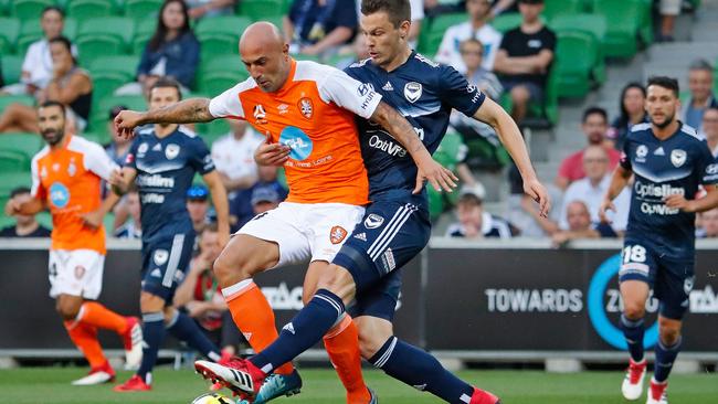 Brisbane Roar’s Massimo Maccarone is challenged by Melbourne Victory defender James Donachie on Friday night.