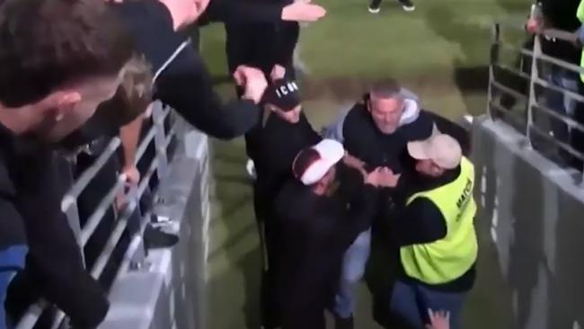 Volunteers then need to hold the man back, before he breaks through them to try and confront Mandurah players in the changerooms.