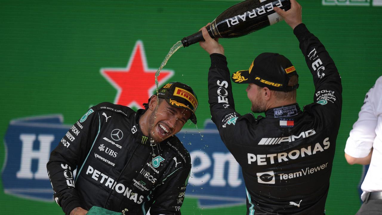 Mercedes' British driver Lewis Hamilton (L) and teammate Valtteri Bottas celebrate on the podium in Brazil. Photo by CARL DE SOUZA / AFP.