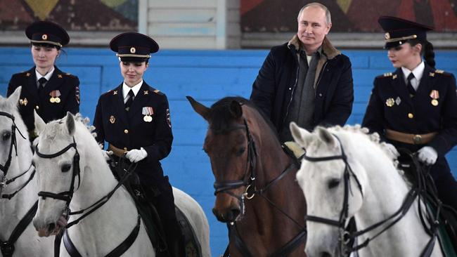 Russian President Vladimir Putin rides a horse along with female police officers as he visits a mounted police regiment ahead of International Women's Day, Moscow, March 7, 2019. Picture: SPUTNIK / AFP